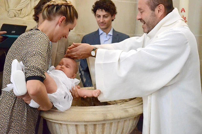 enfant qui se fait baptiser au sein de l'église catholique